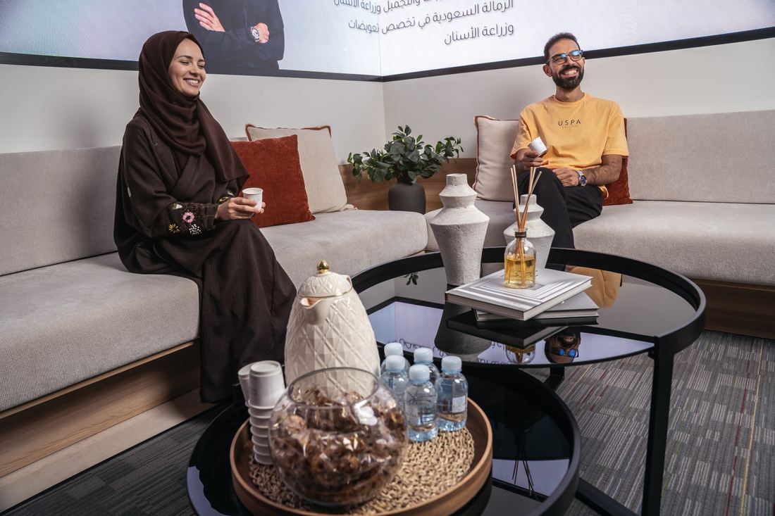 Patients seated in the Tam Dental waiting lounge in Jeddah with refreshments on a low table.